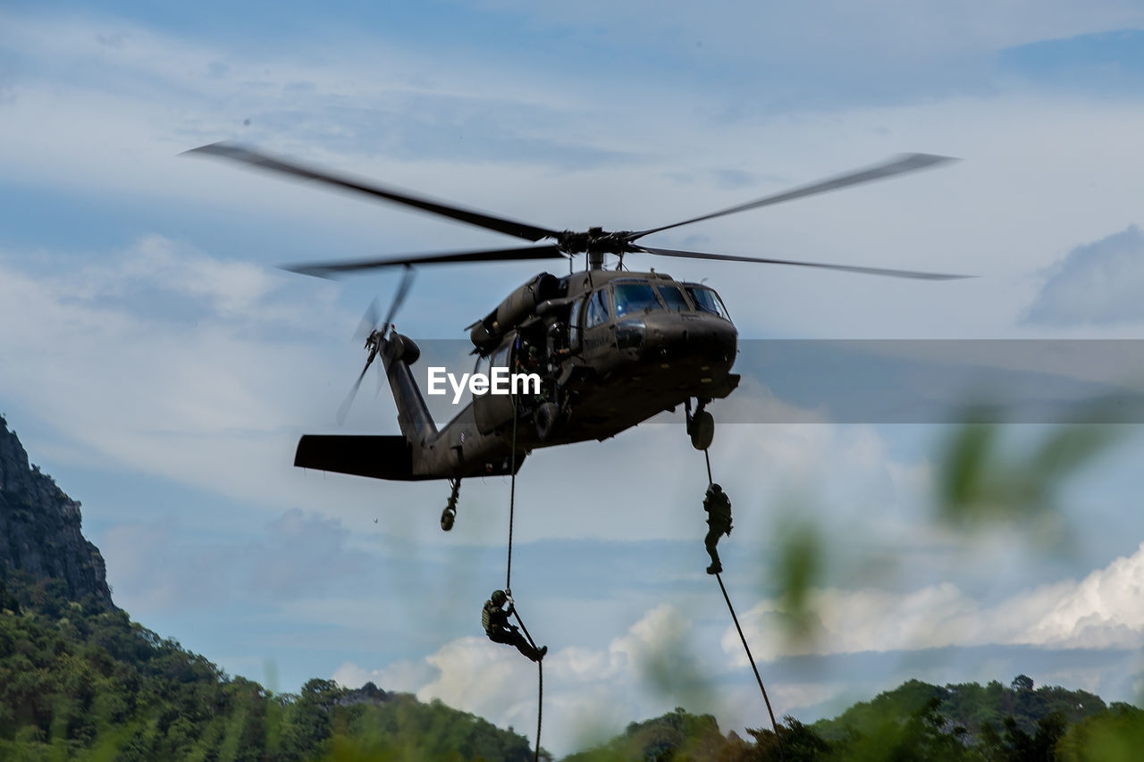 Low angle view of helicopter flying against sky