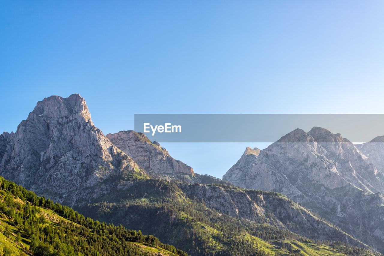 Scenic view of mountains against clear blue sky