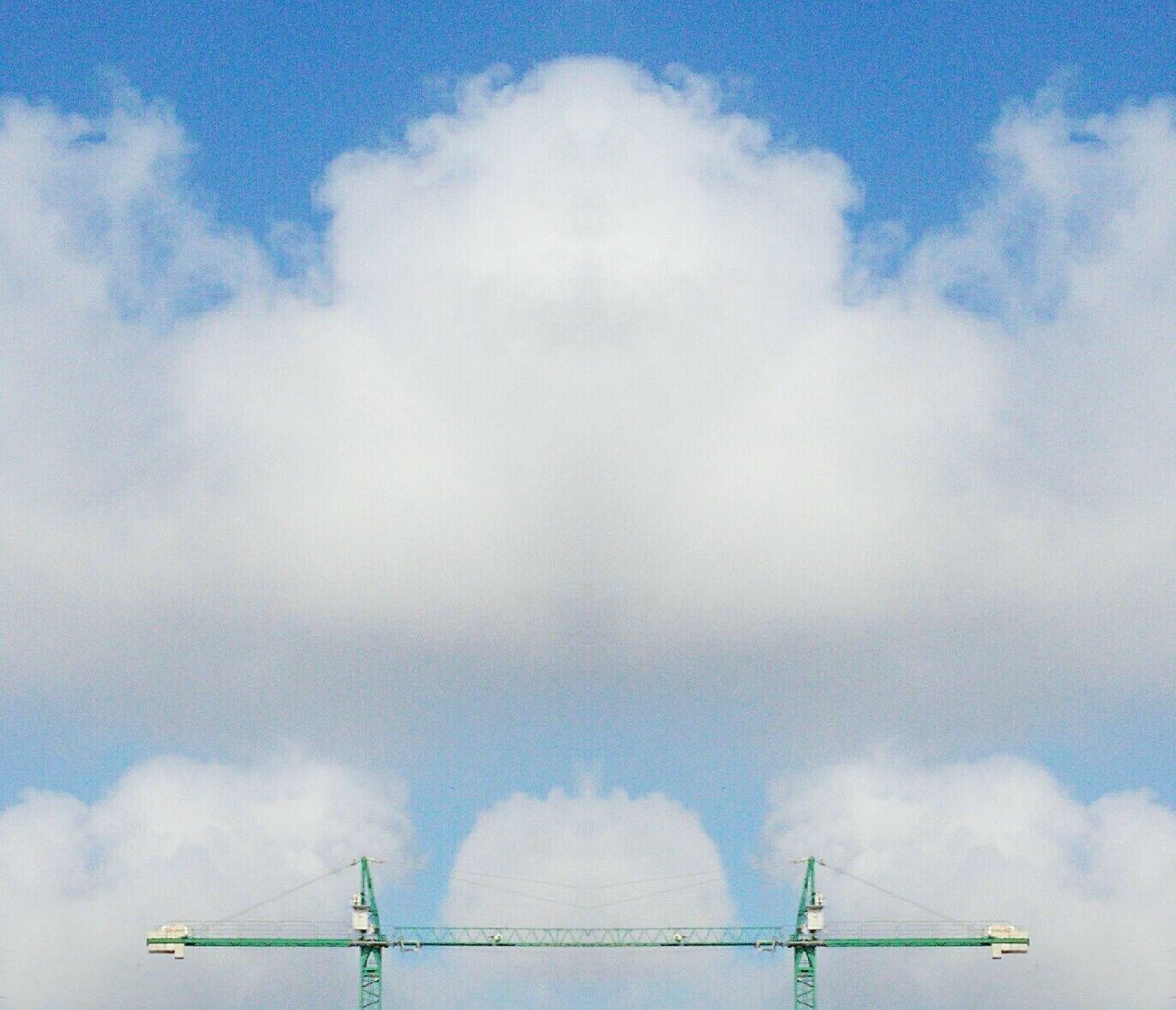 Low angle view of crane against cloudy sky