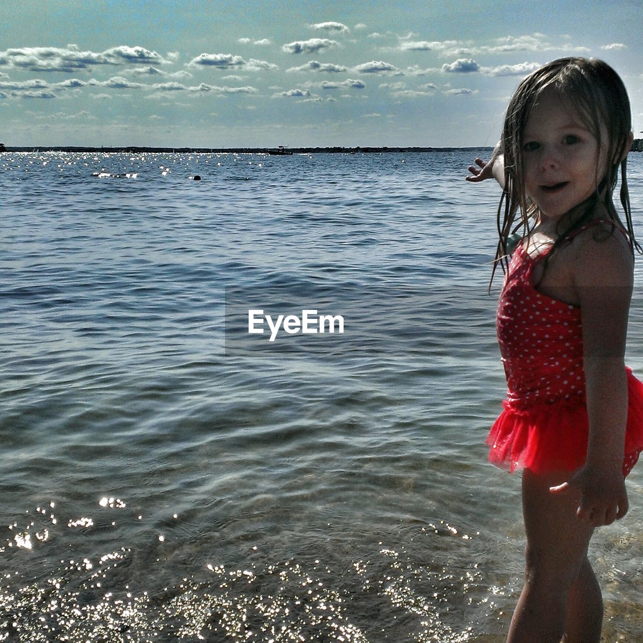 Side view portrait of cute girl standing in sea