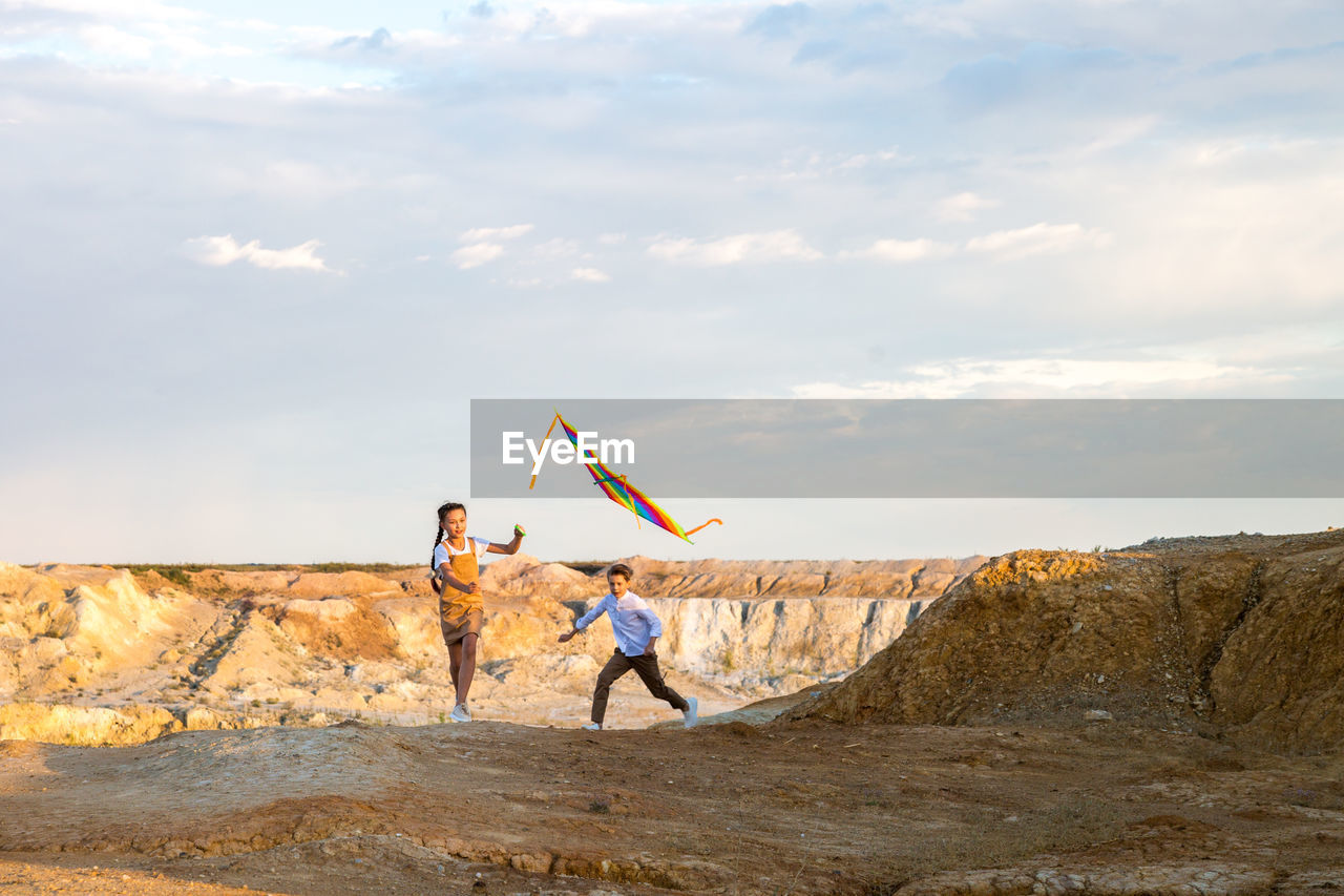 Children play active games with a kite outdoors.