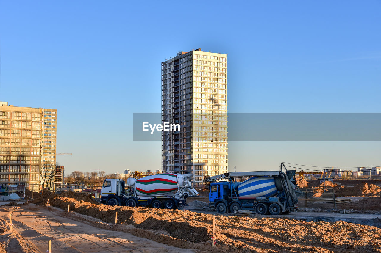 Heavy mixer concrete trucks waiting for to be loaded concrete at a construction site. 