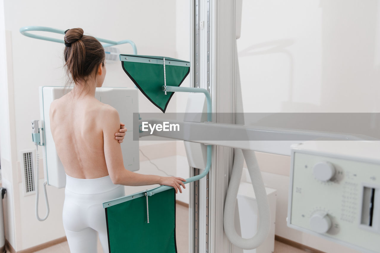 Shirtless woman scanning chest at clinic