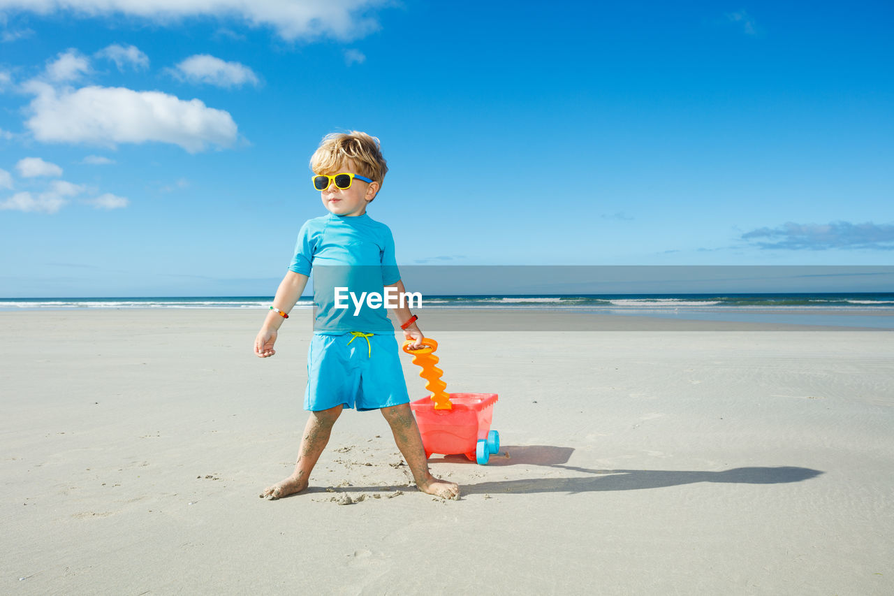 full length of boy standing at beach