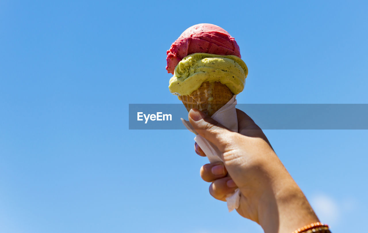 Gelati ice cream cone held up to the hot summer sky