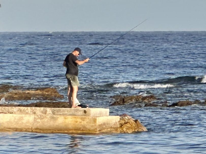 water, sea, one person, full length, nature, sky, fishing, rod, activity, men, leisure activity, standing, adult, fishing rod, horizon over water, horizon, motion, shore, beauty in nature, clear sky, lifestyles, side view, day, coast, holding, sports, outdoors, casting, rock, land, scenics - nature, beach, sunny, ocean, holiday, vacation, recreation