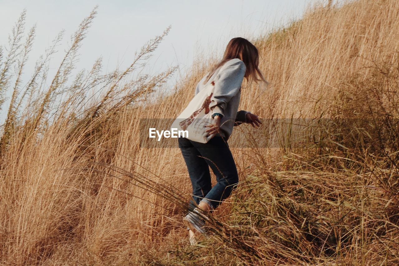 Side view of woman walking on field