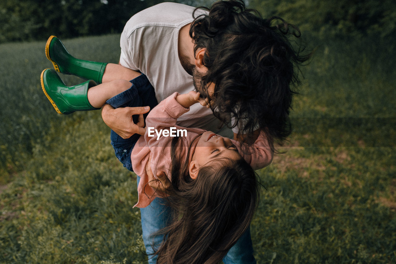 Father playing with daughter outdoors