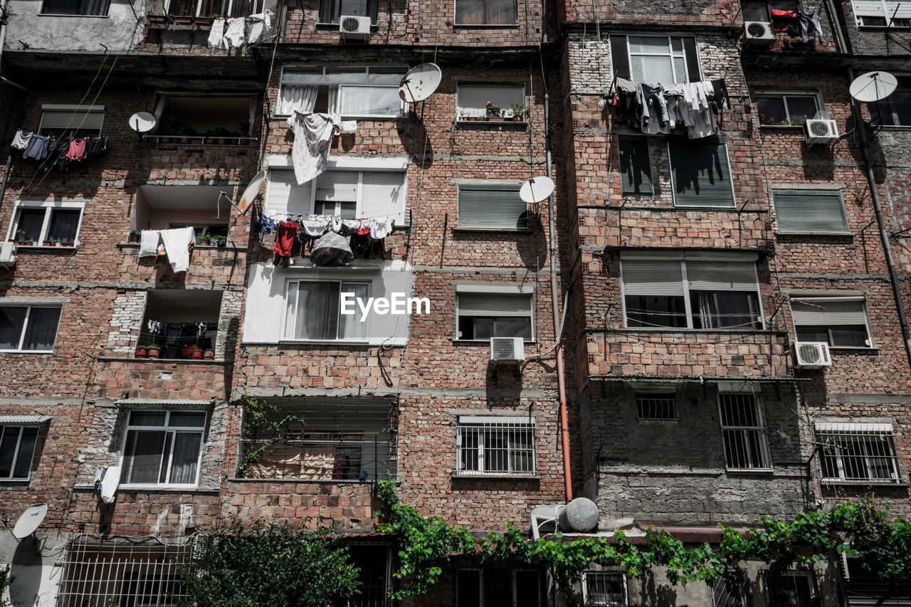 LOW ANGLE VIEW OF OLD BUILDING WITH APARTMENT BUILDINGS