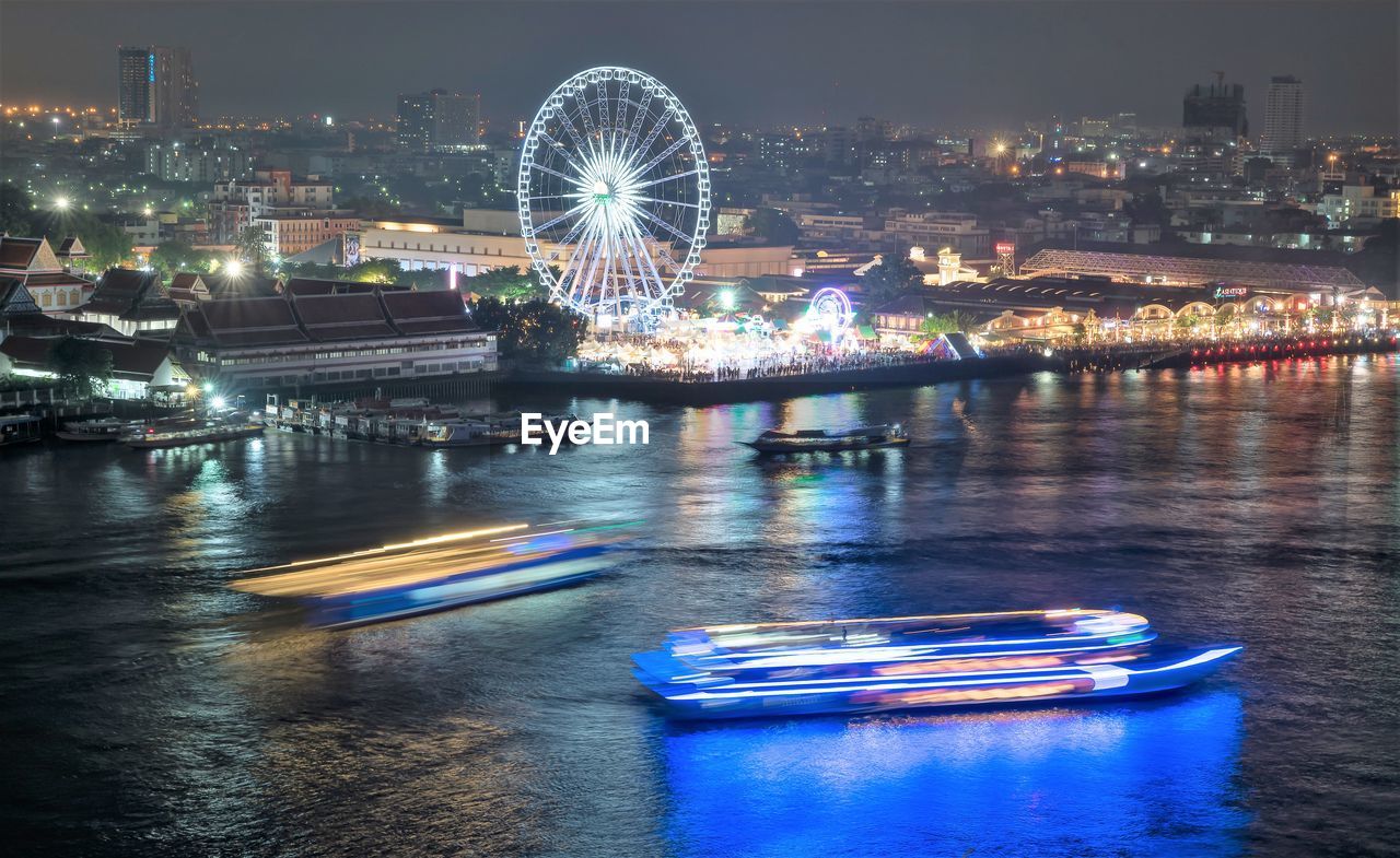 ILLUMINATED FERRIS WHEEL IN AMUSEMENT PARK