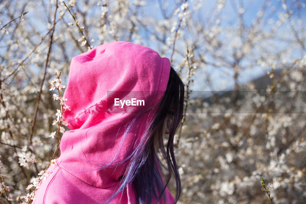 PORTRAIT OF WOMAN ON PINK TREE