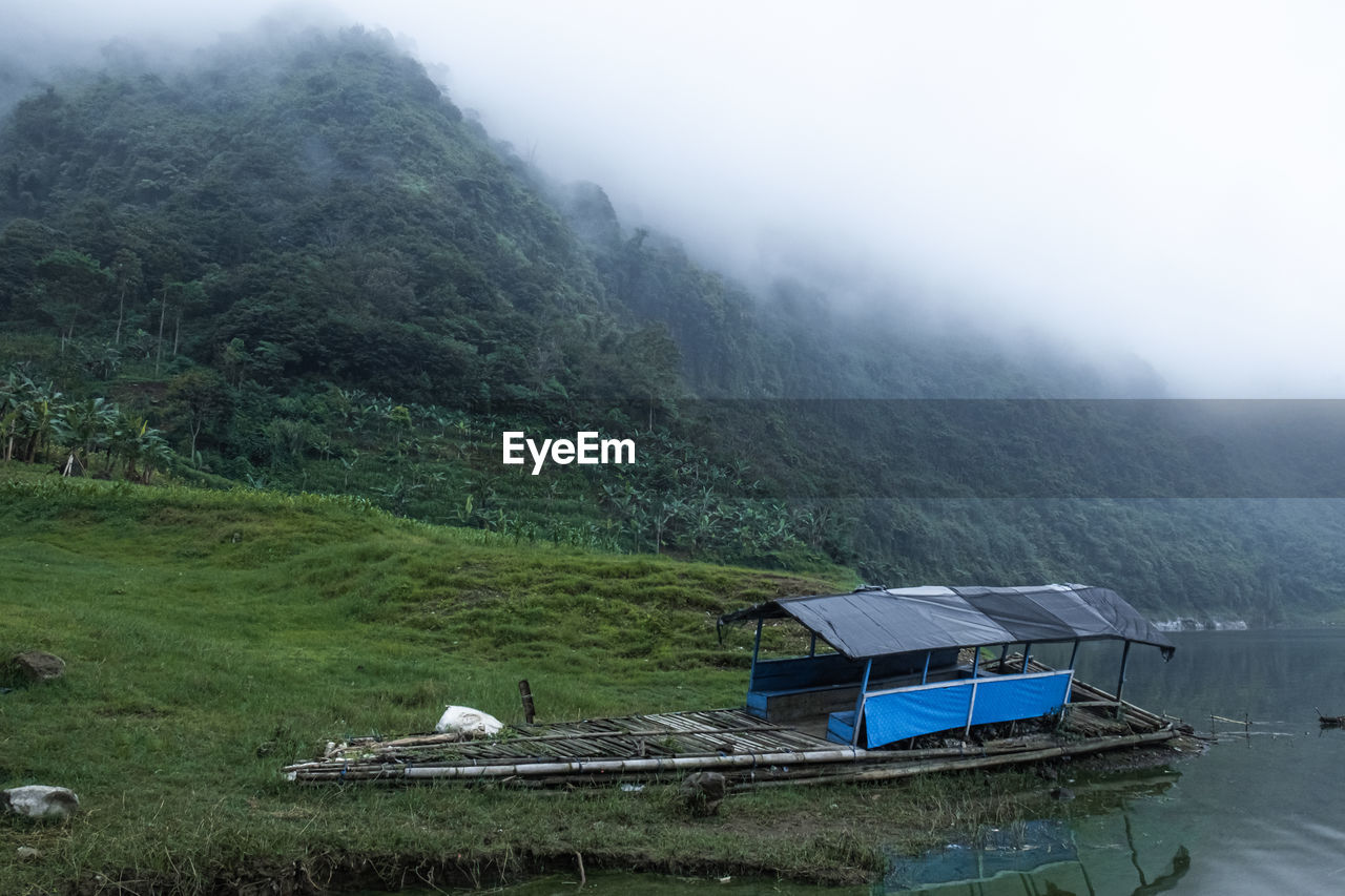 HIGH ANGLE VIEW OF HOUSE ON LAND AGAINST MOUNTAIN