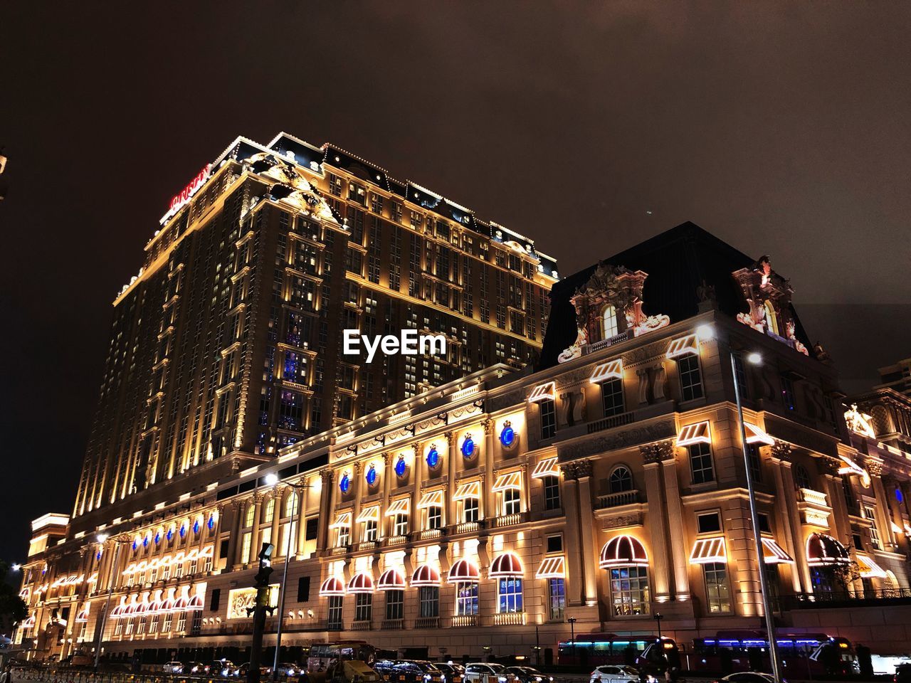 LOW ANGLE VIEW OF ILLUMINATED BUILDINGS AGAINST SKY AT NIGHT