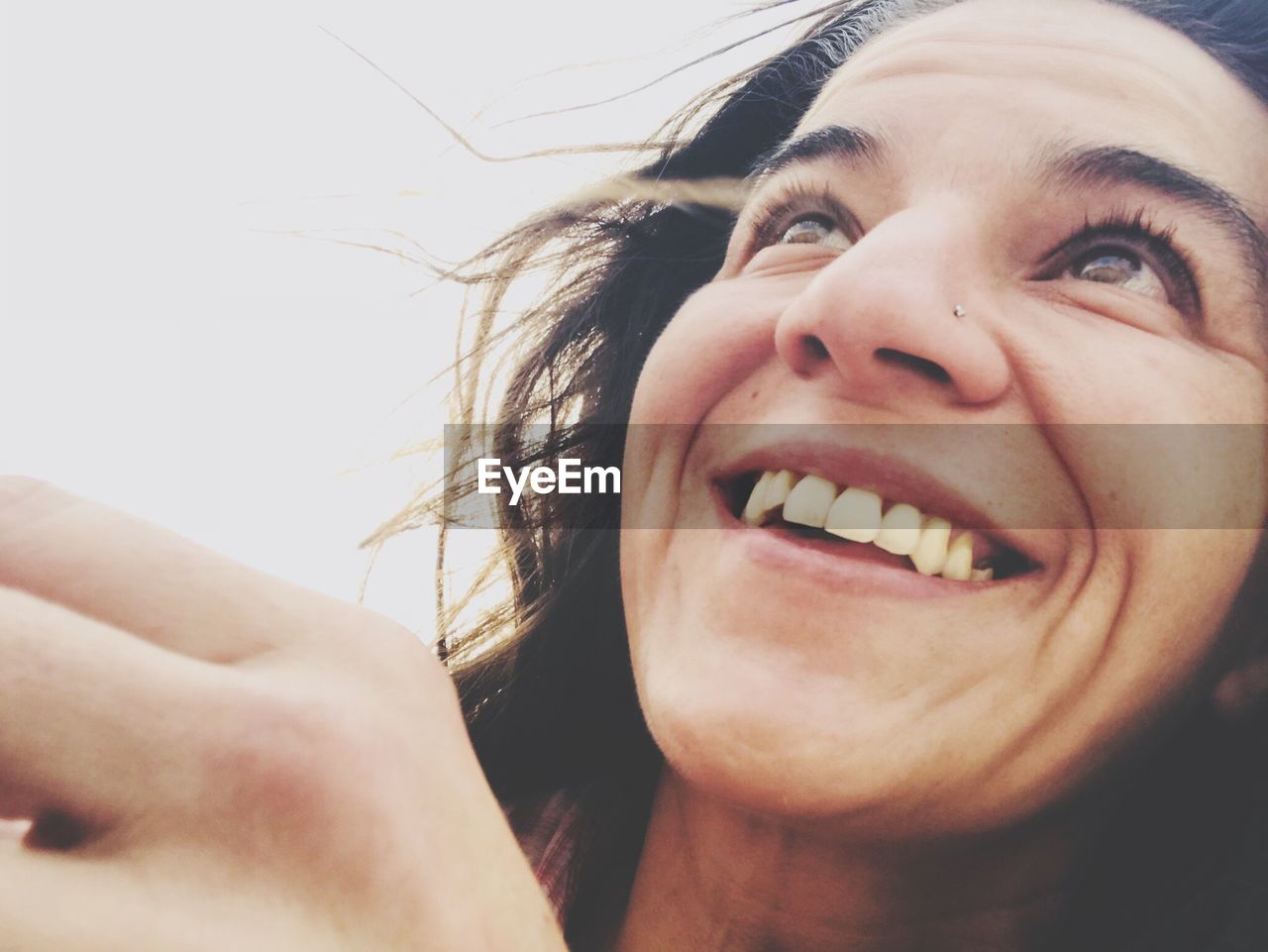 Close-up of smiling mid adult woman looking away against sky