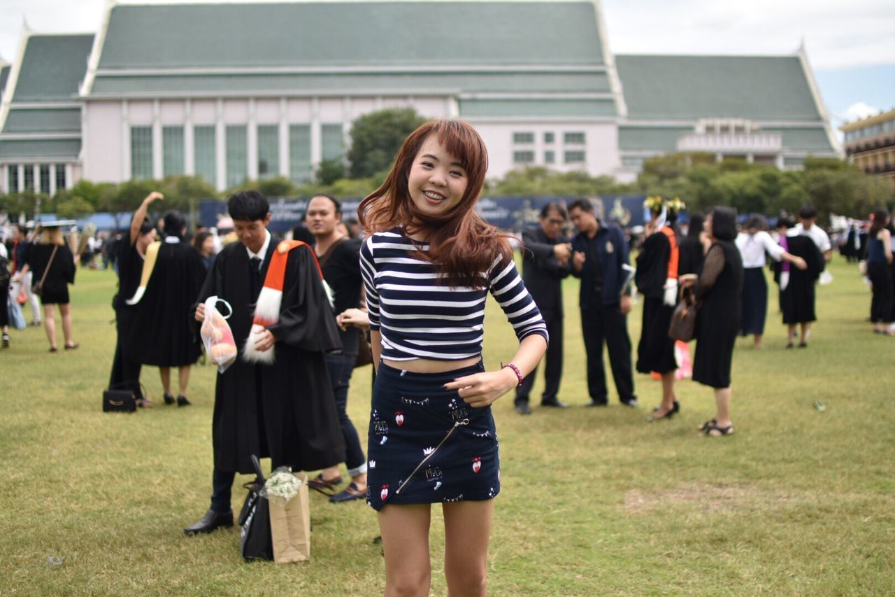 FULL LENGTH OF HAPPY WOMAN STANDING IN PARK