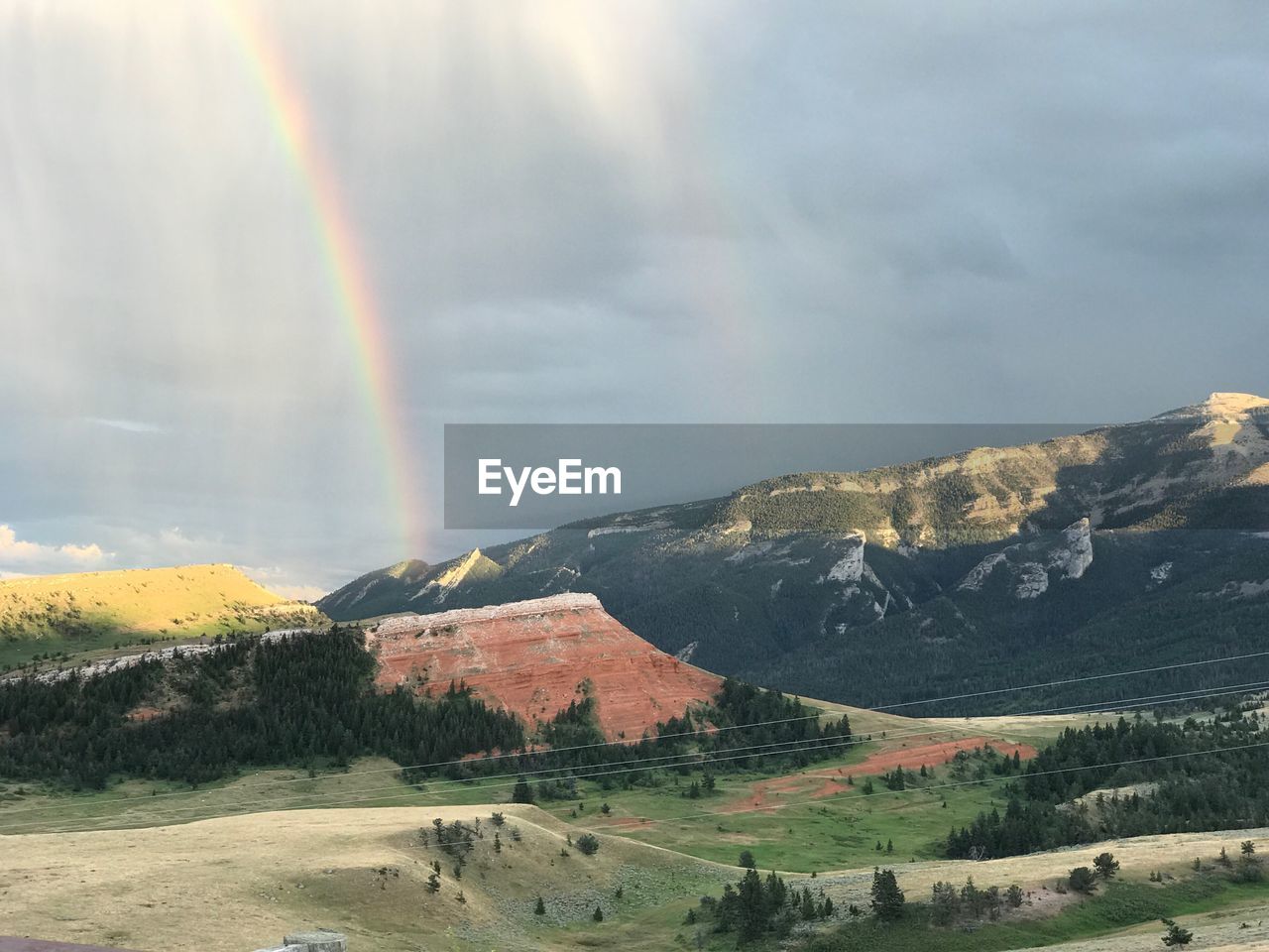 RAINBOW OVER MOUNTAIN AGAINST SKY