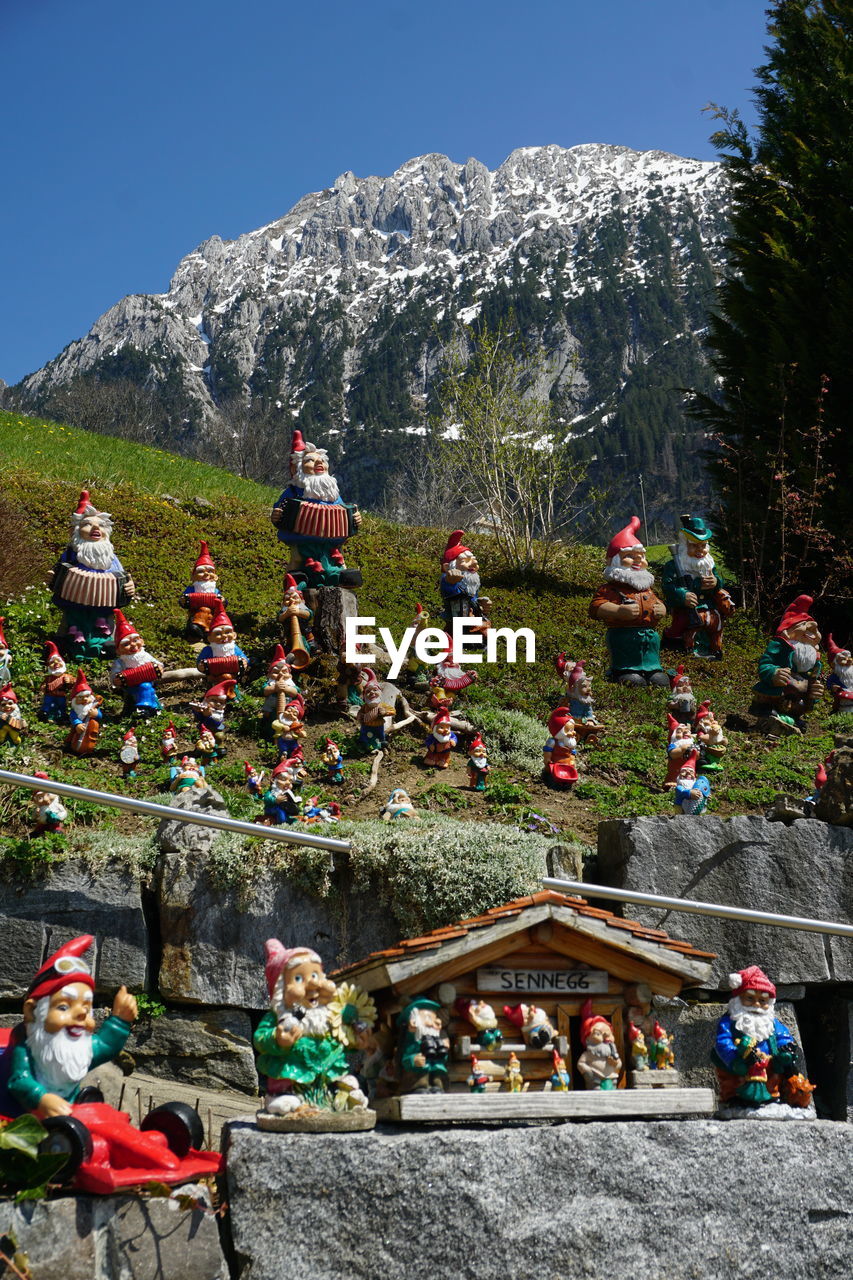 GROUP OF PEOPLE IN TEMPLE AGAINST MOUNTAIN