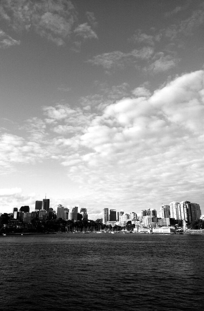 Sea and urban skyline against sky