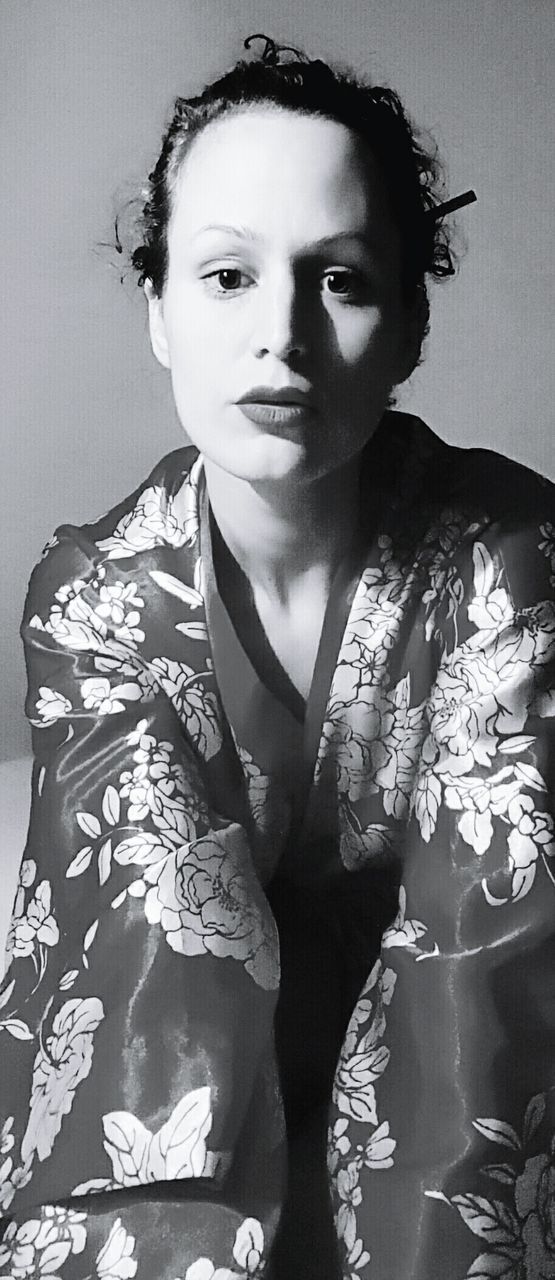 Portrait of woman wearing traditional japanese kimono against wall at home