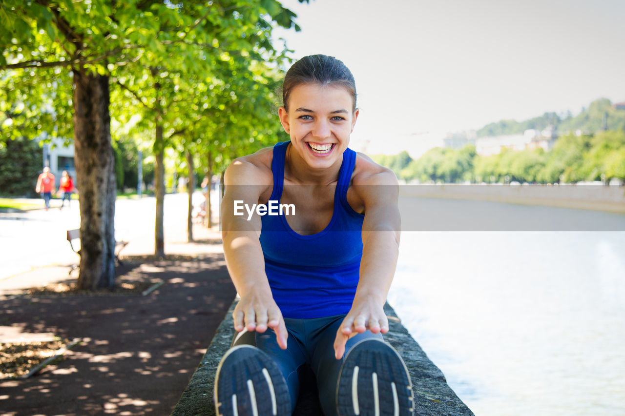 Portrait of teenage girl exercising on retaining wall