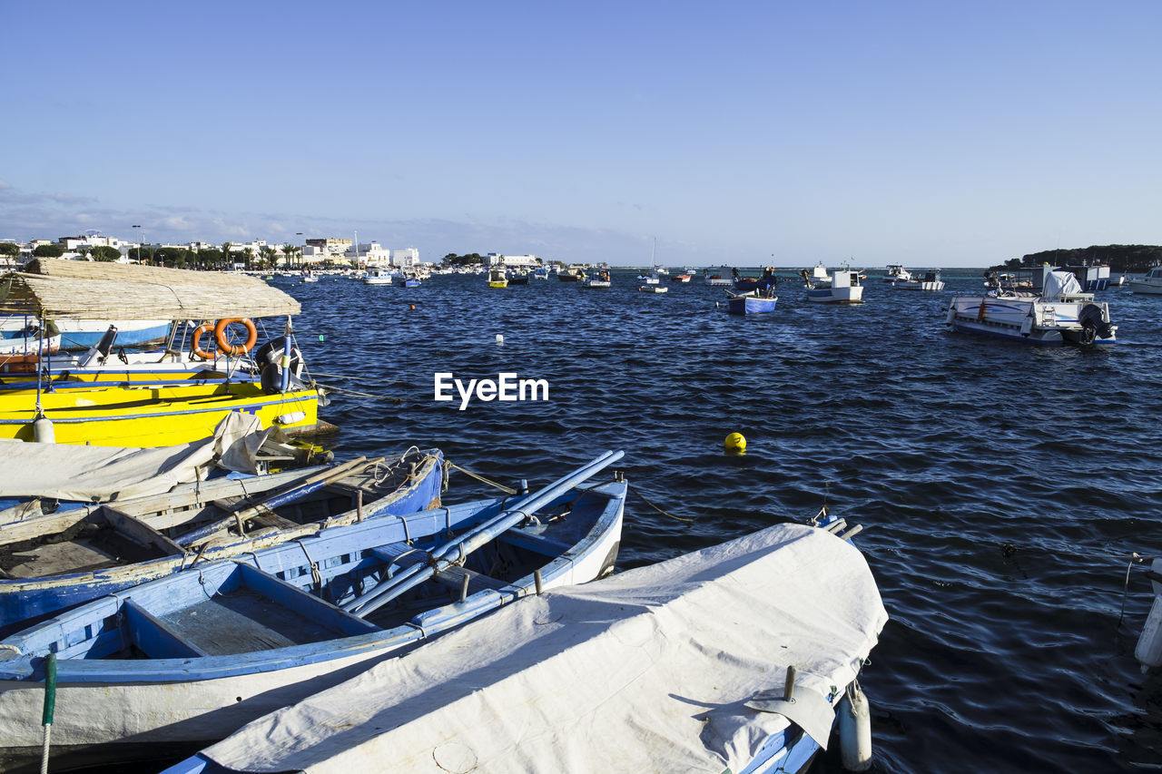 Boats moored on sea against sky at porto cesare