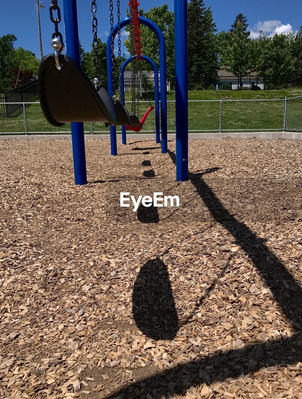 SHADOW OF SWING HANGING ON PLAYGROUND AGAINST SKY