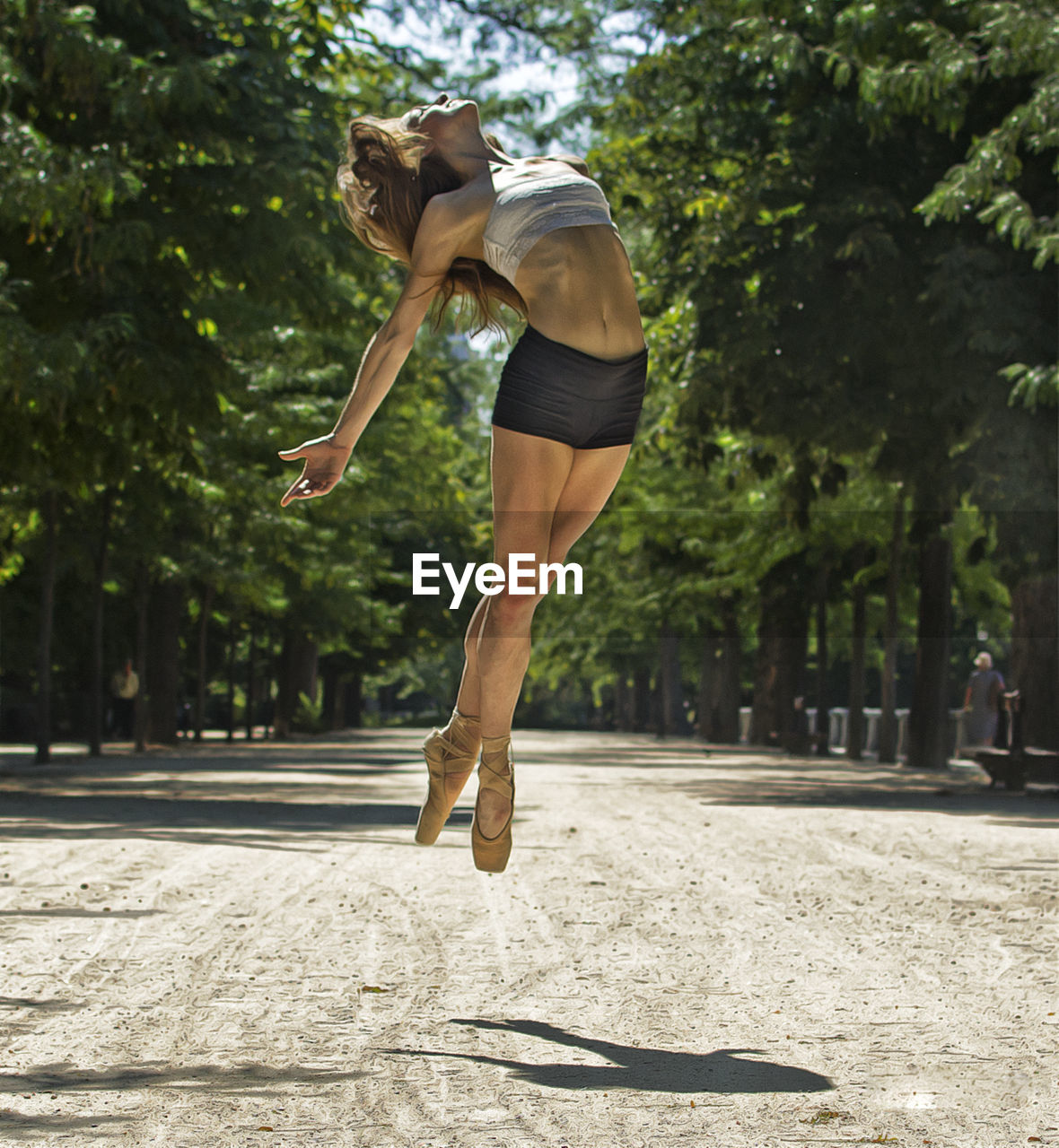 Ballerina pose jumping outdoors, lifestyle concept.