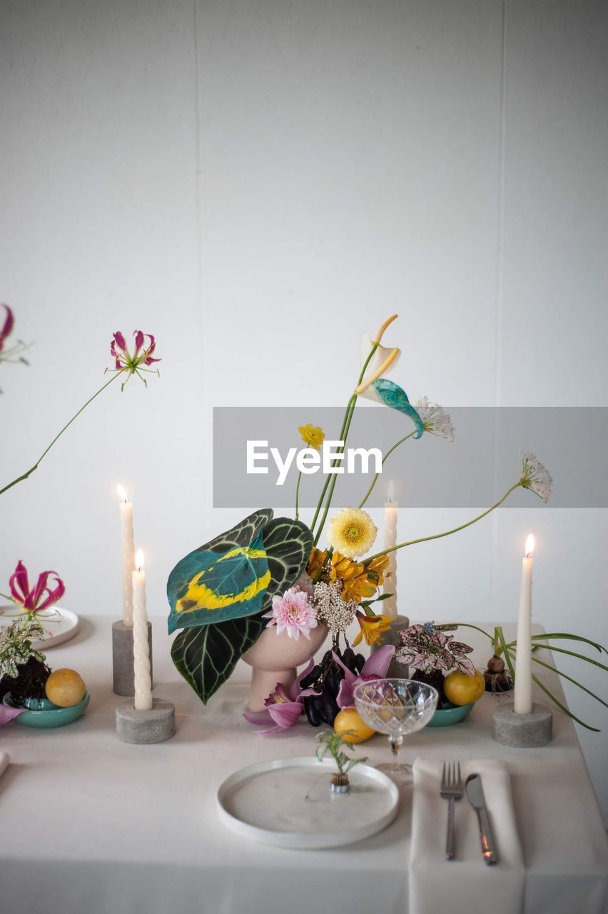 Flower vase on table against wall