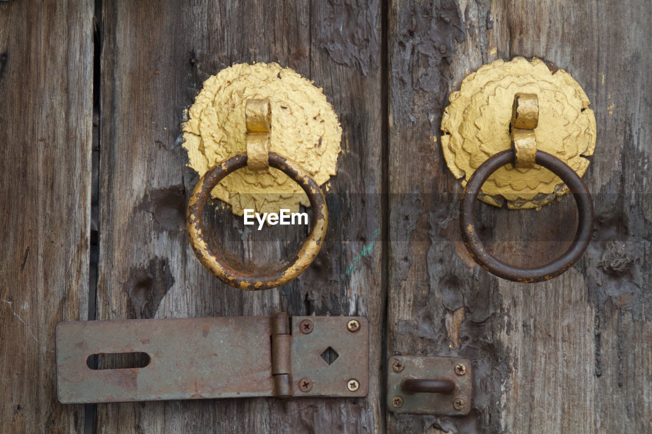 CLOSE-UP OF DOOR KNOCKER ON WOODEN POST