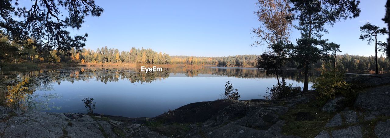 Scenic view of lake by trees against sky