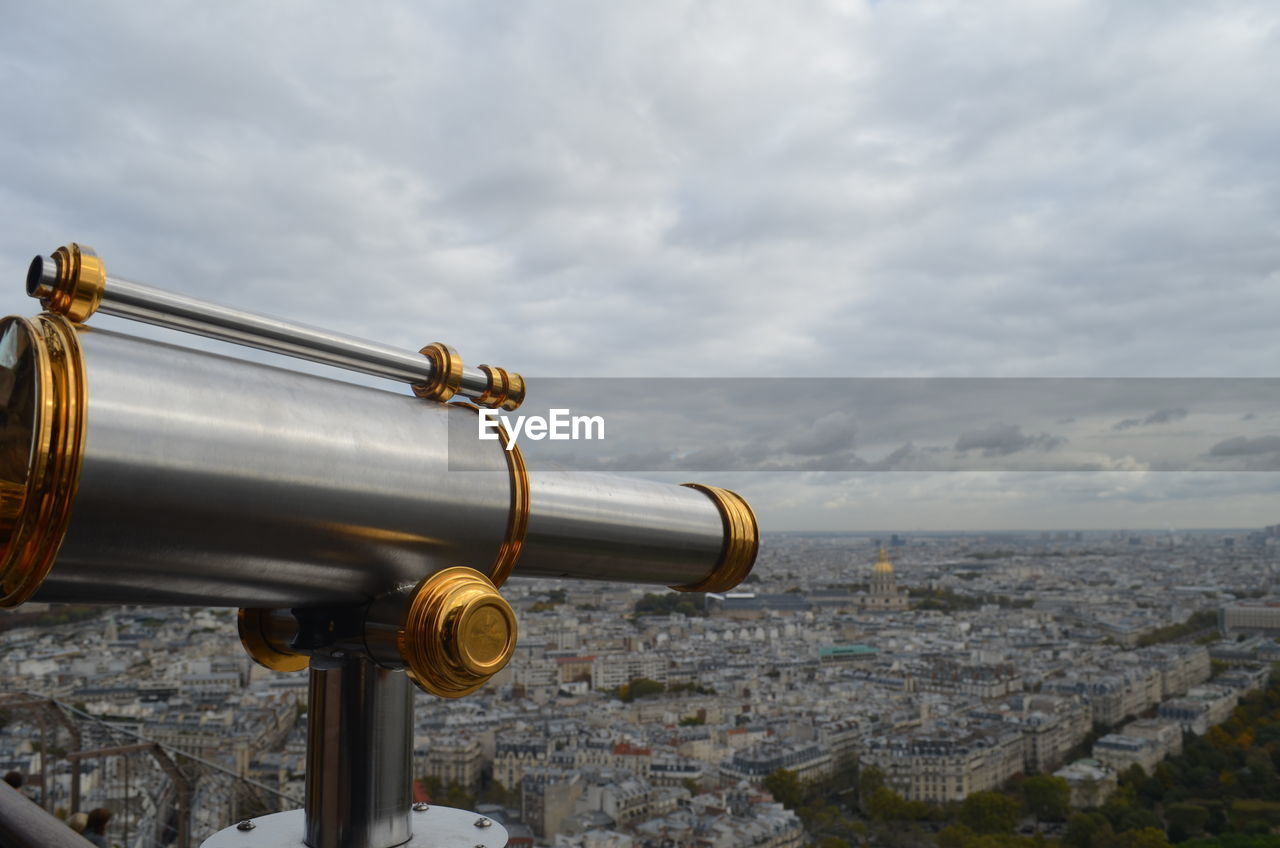 Close-up of coin-operated binoculars and cityscape