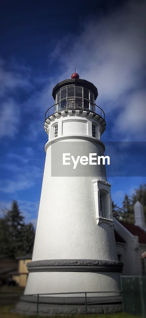 LOW ANGLE VIEW OF LIGHTHOUSE AGAINST BUILDING AND SKY