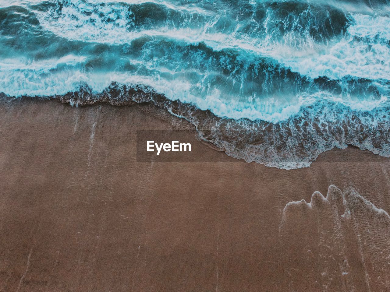 High angle view of waves rushing towards shore