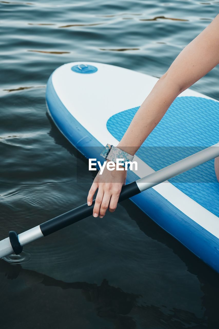 Close-up of woman paddleboarding in sea