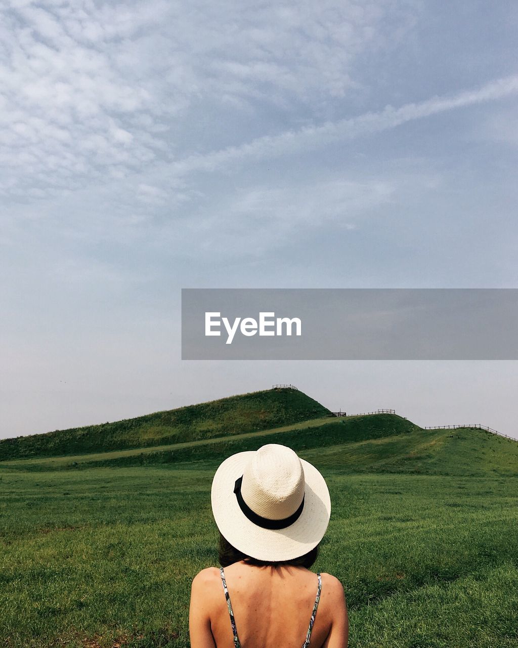 Woman wearing hat on field against sky