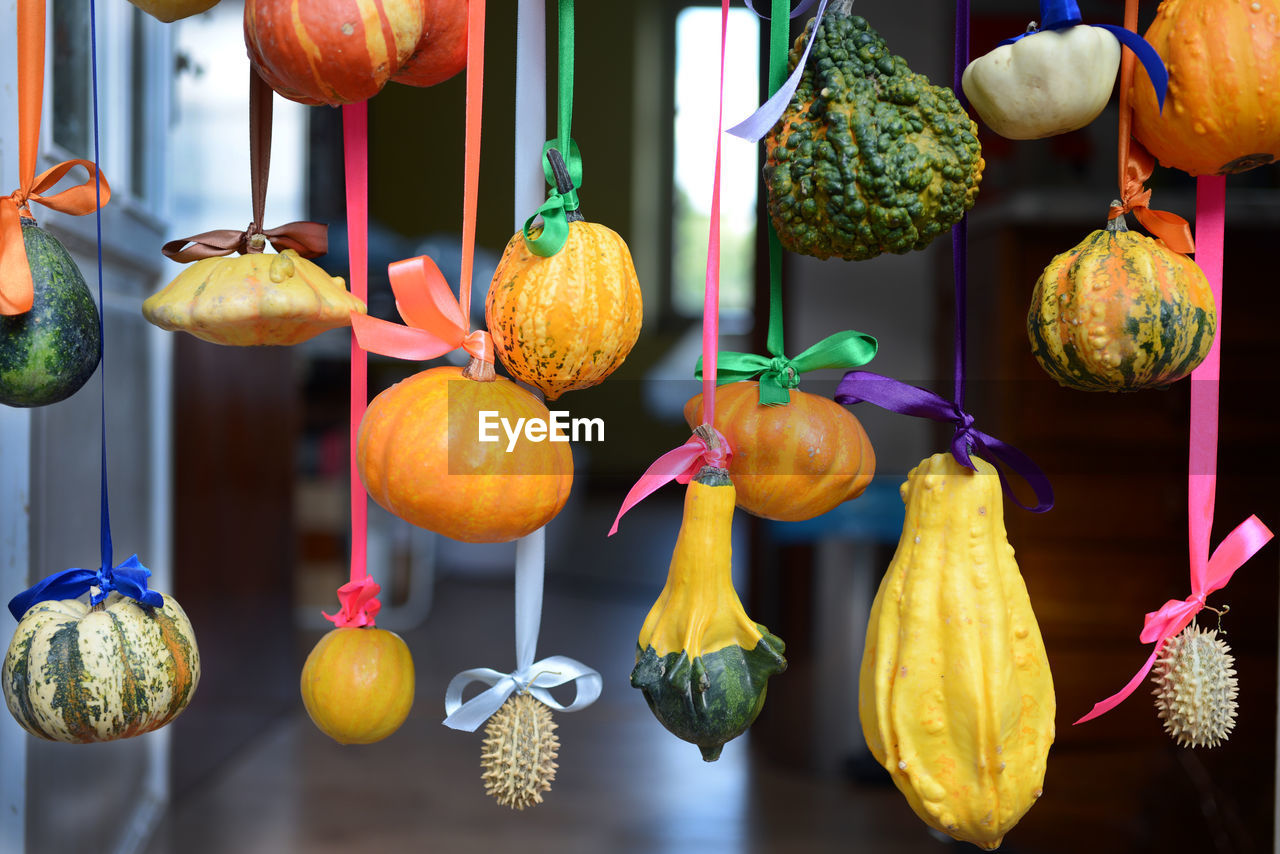 CLOSE-UP OF ORANGE FRUITS HANGING IN MARKET