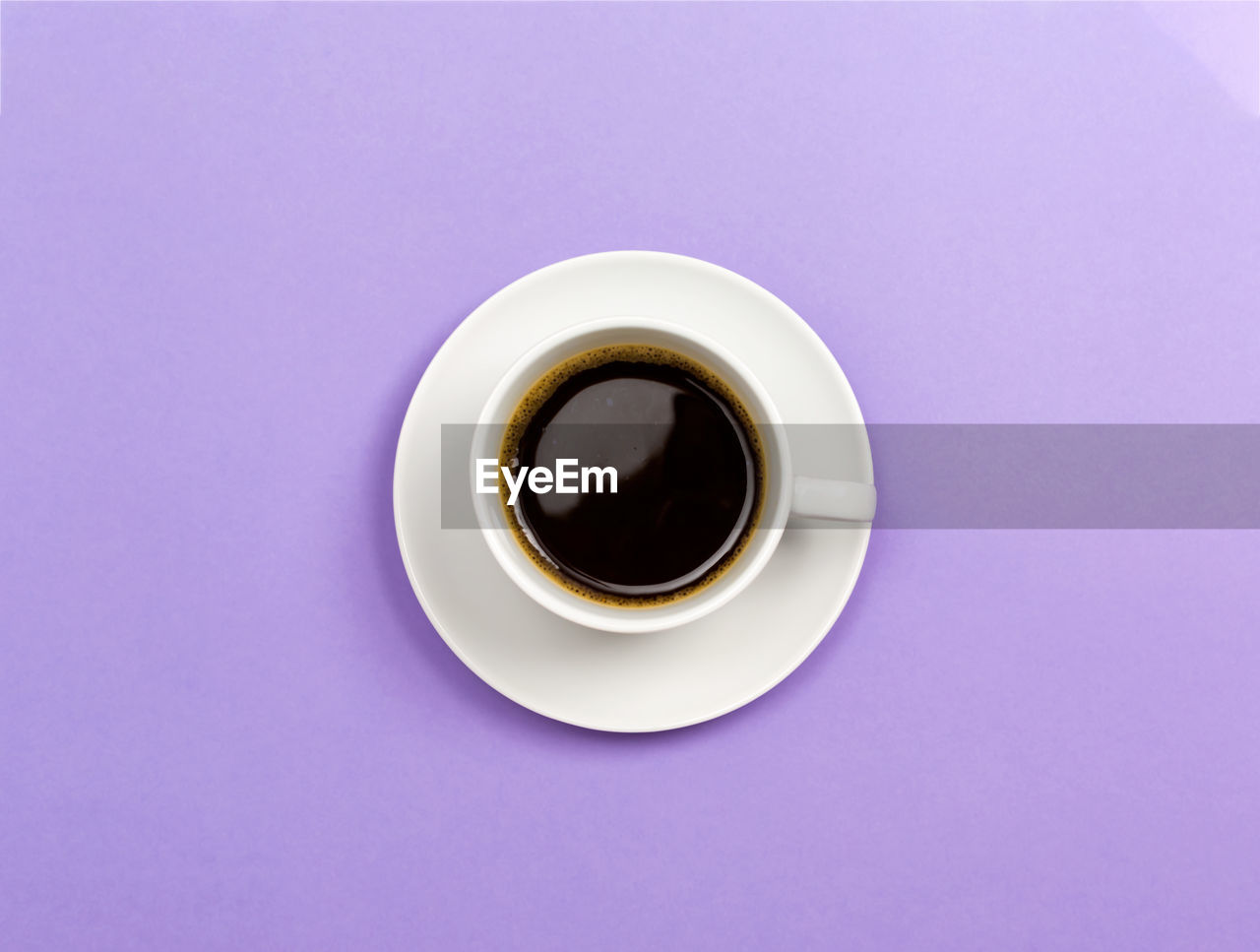 DIRECTLY ABOVE SHOT OF COFFEE CUP ON TABLE AGAINST BLACK BACKGROUND