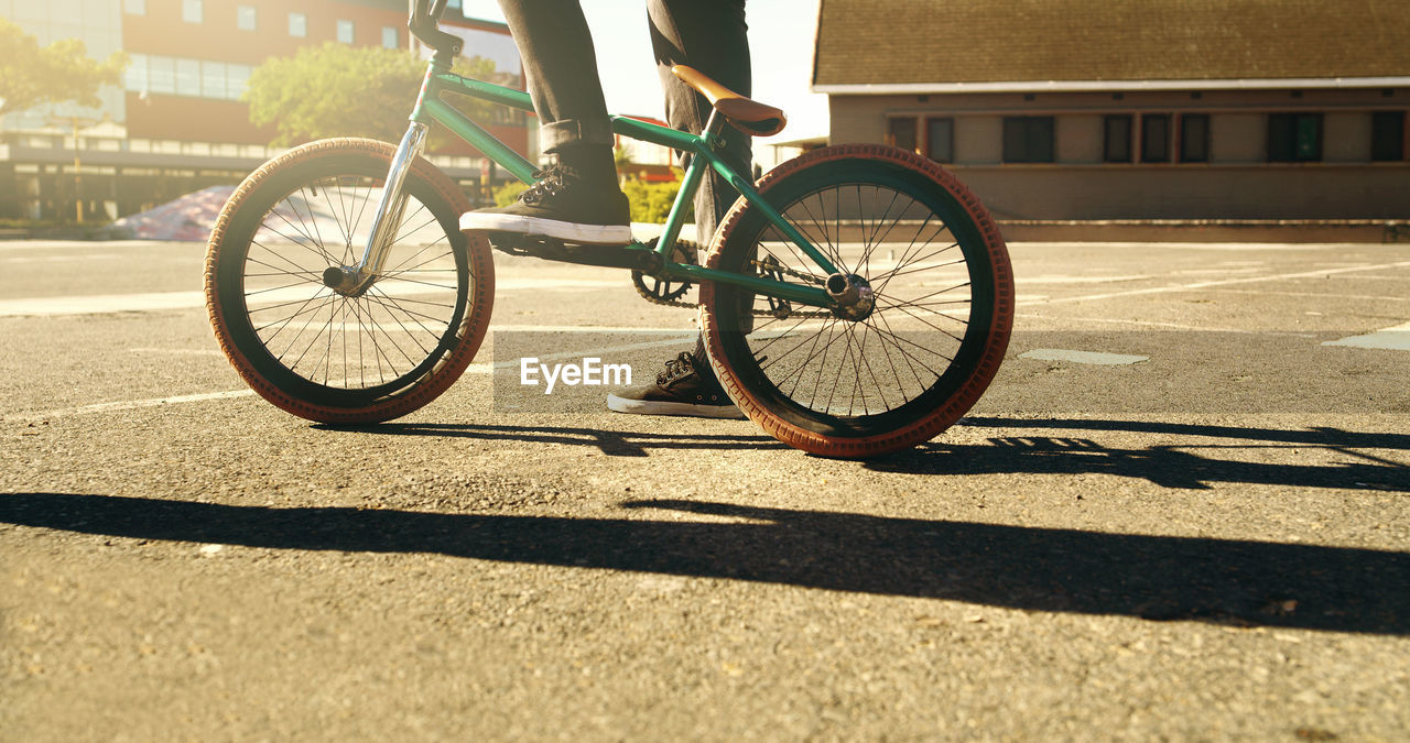 low section of man riding bicycle on road