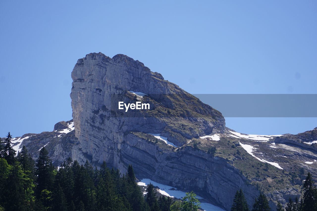 Scenic view of snowcapped mountains against clear blue sky