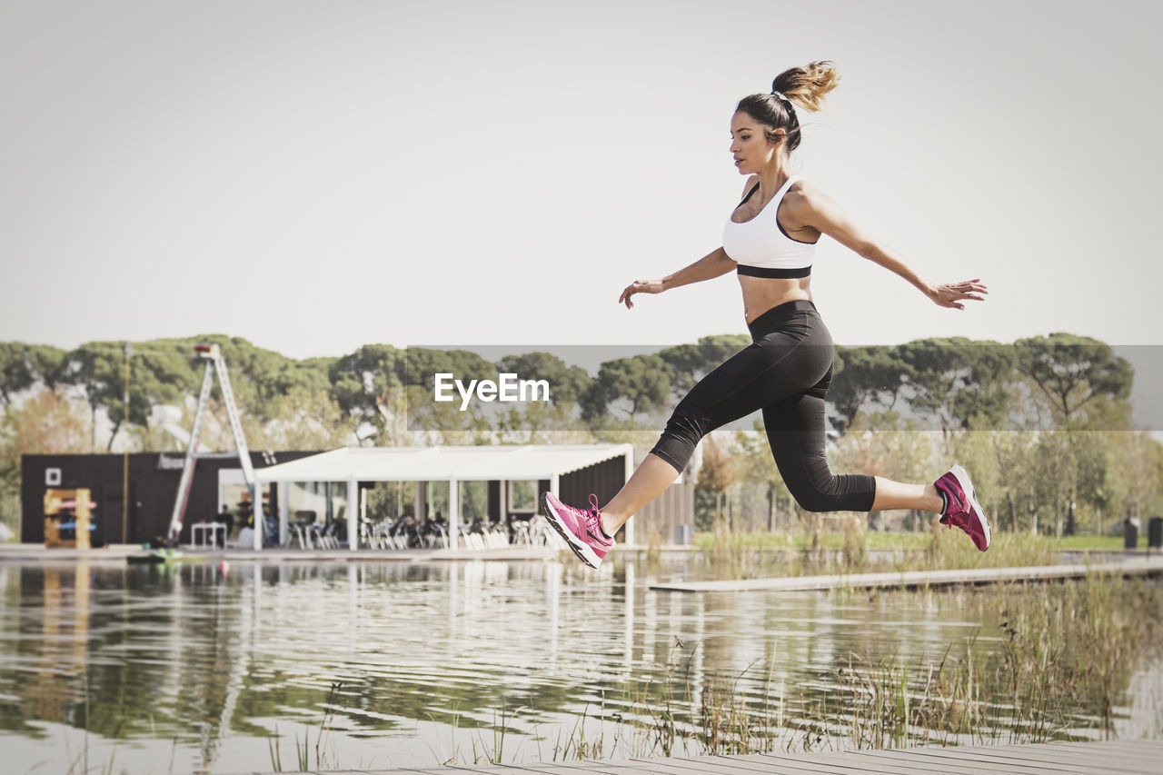 Woman jumping by water