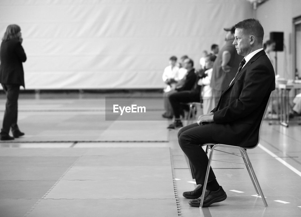 Side view of businessman sitting on chair looking away