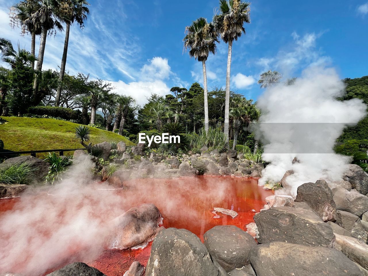 heat, smoke, tree, nature, plant, sky, cloud, steam, environment, beauty in nature, tropical climate, landscape, land, geology, water, day, burning, rock, fire, outdoors, no people, palm tree, scenics - nature, travel destinations, volcano, body of water, non-urban scene, mountain, physical geography, water feature, travel, accidents and disasters, power in nature