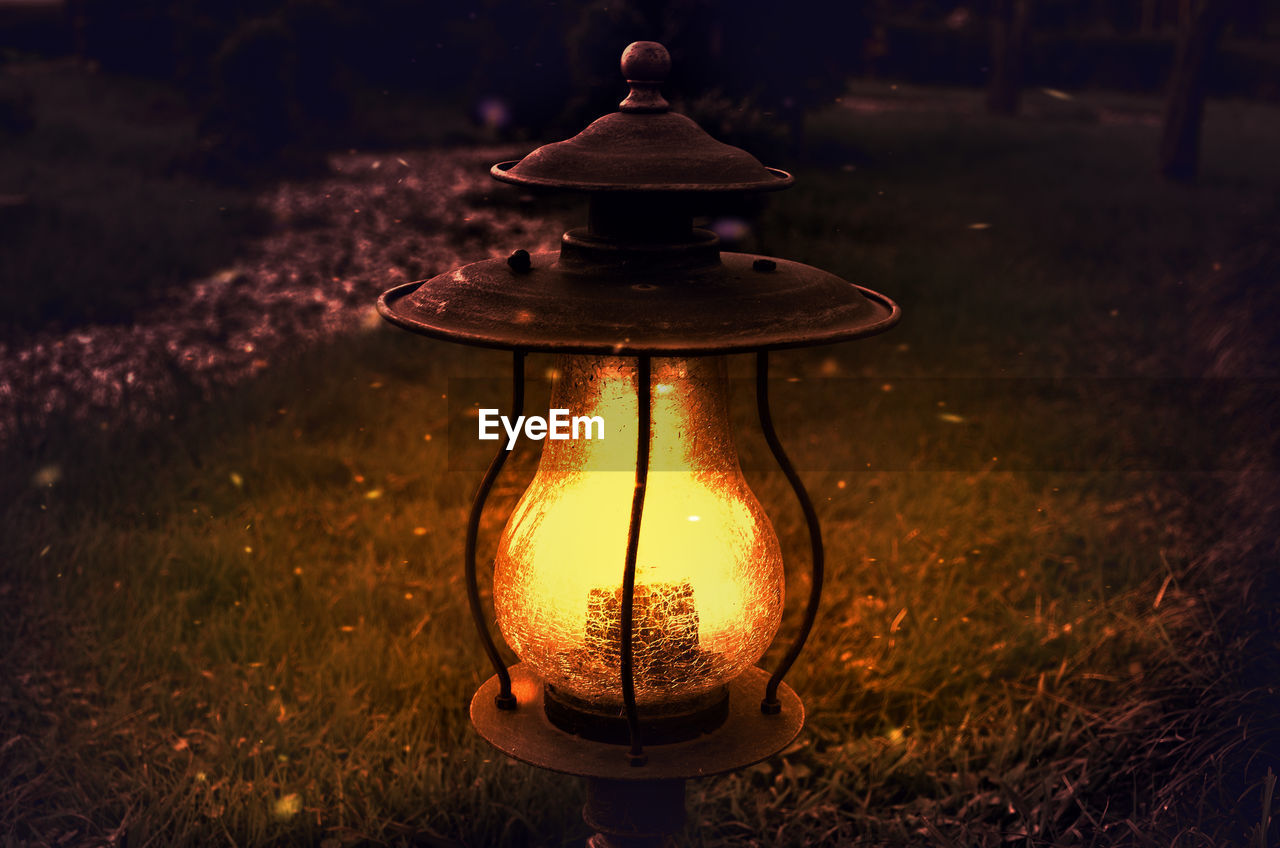 CLOSE-UP OF ILLUMINATED LANTERN ON TABLE