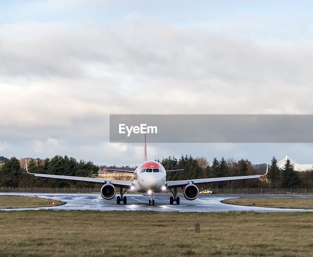 Airplane at airport runway against sky