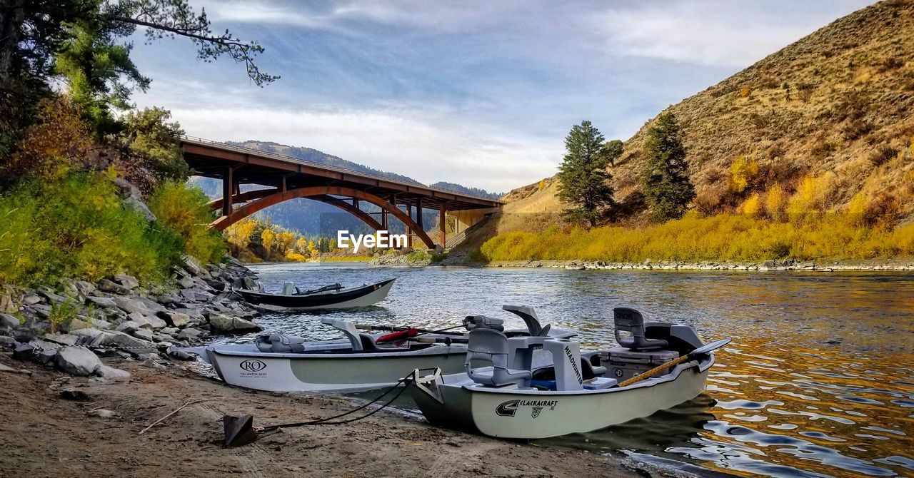 BOATS MOORED ON RIVER AGAINST SKY