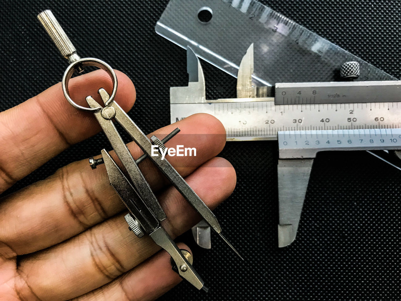 Cropped hand with tools at table