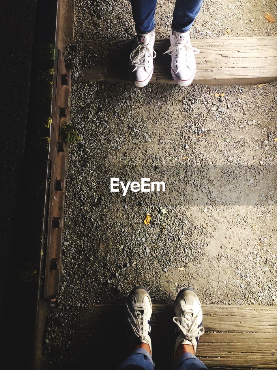 Low section of people standing on railroad ties