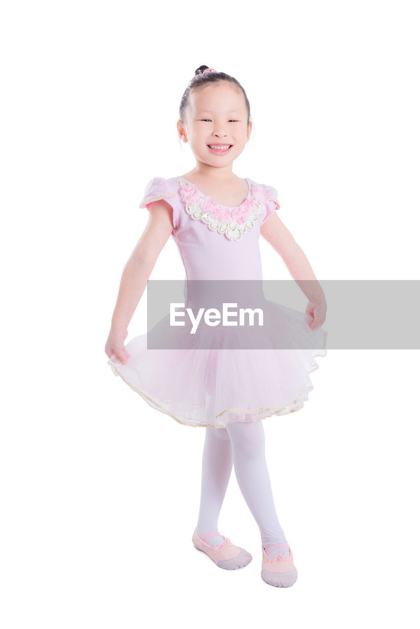 Portrait of smiling girl standing against white background