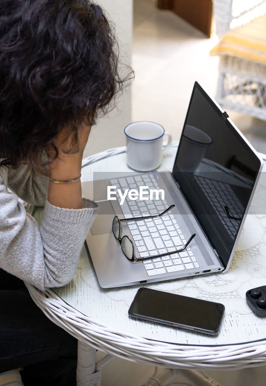 high angle view of woman using laptop at table