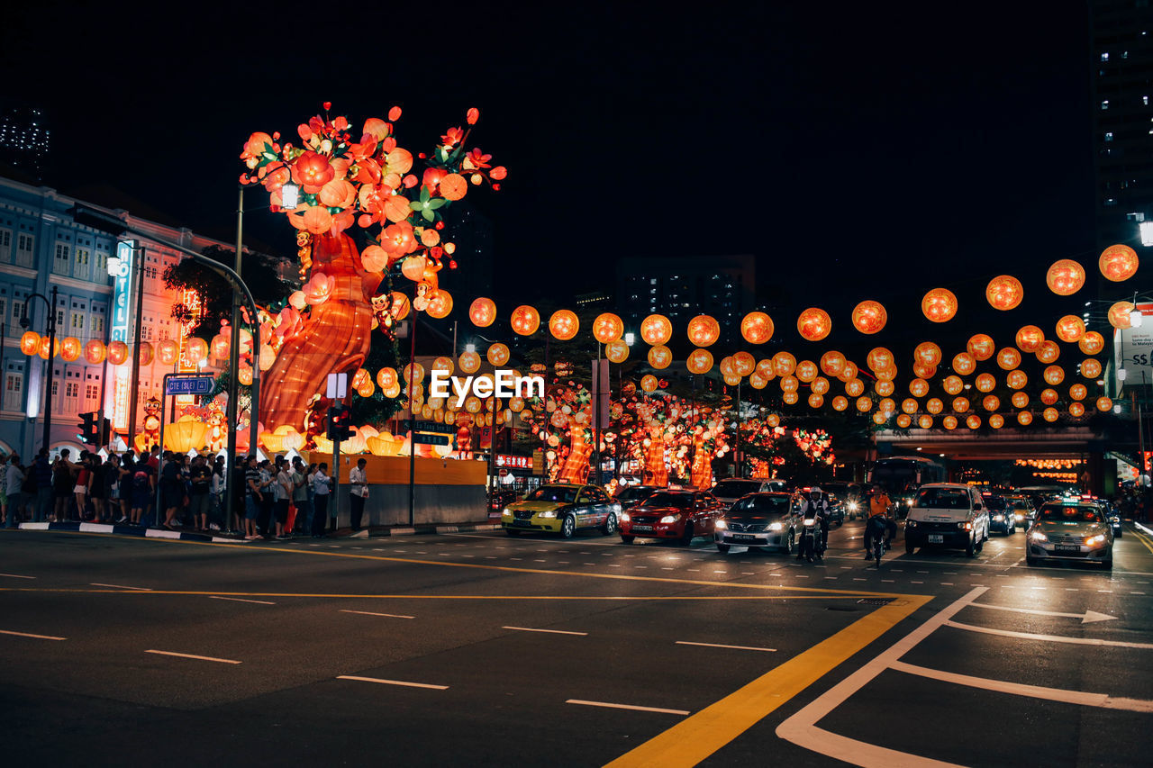 Illuminated lanterns decorated above street at night